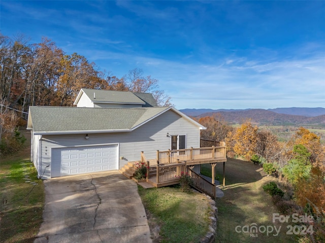 view of front of home with a garage and a deck with mountain view