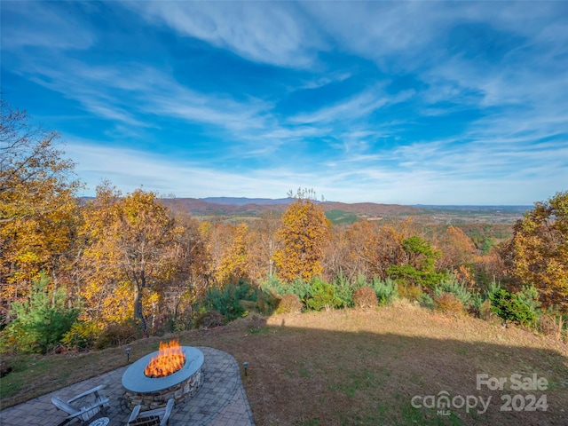 view of yard with a mountain view, a patio, and a fire pit