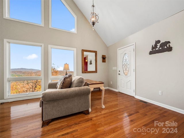 living room with a mountain view, high vaulted ceiling, and hardwood / wood-style flooring