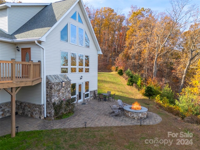 back of property featuring a patio area, a yard, a deck, and an outdoor fire pit