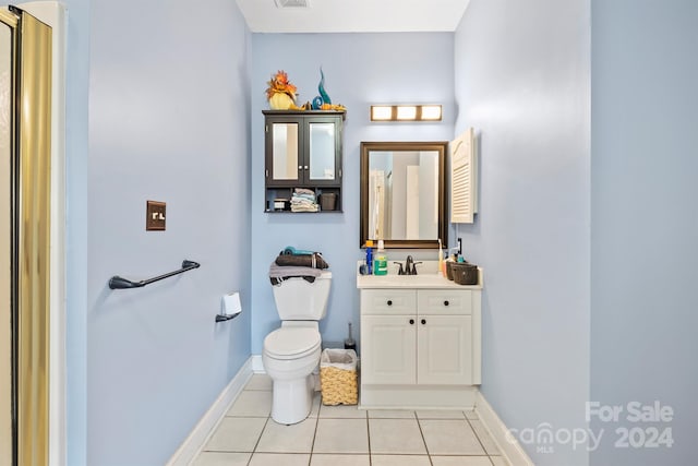 bathroom with toilet, vanity, and tile patterned floors