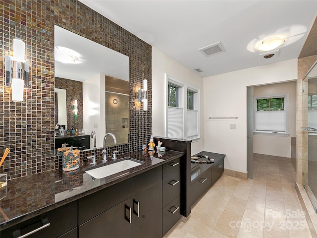 bathroom with a shower with shower door, vanity, and tile patterned flooring