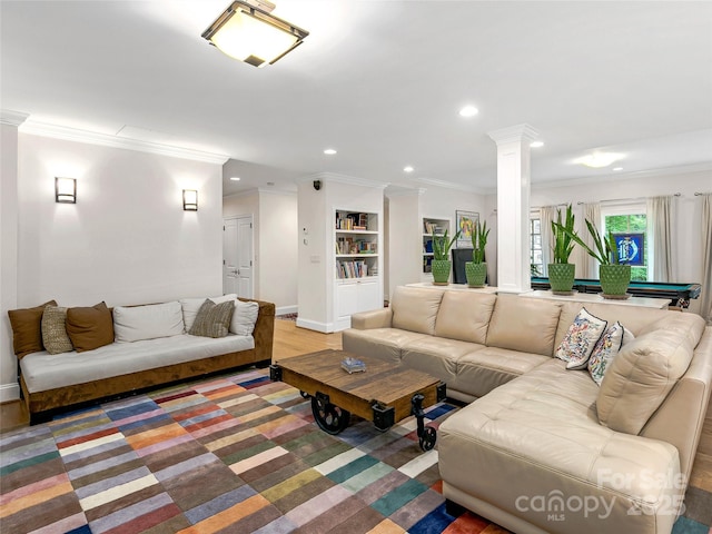 living room featuring ornamental molding, hardwood / wood-style flooring, and decorative columns