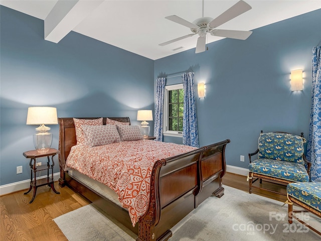 bedroom with light wood-type flooring, ceiling fan, and beamed ceiling