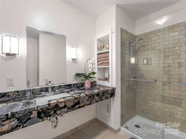 bathroom featuring tile patterned flooring, walk in shower, and sink