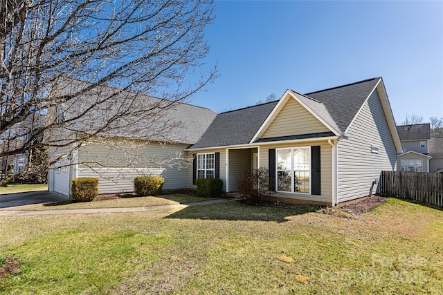 view of front of property featuring fence, aphalt driveway, roof with shingles, a front yard, and a garage