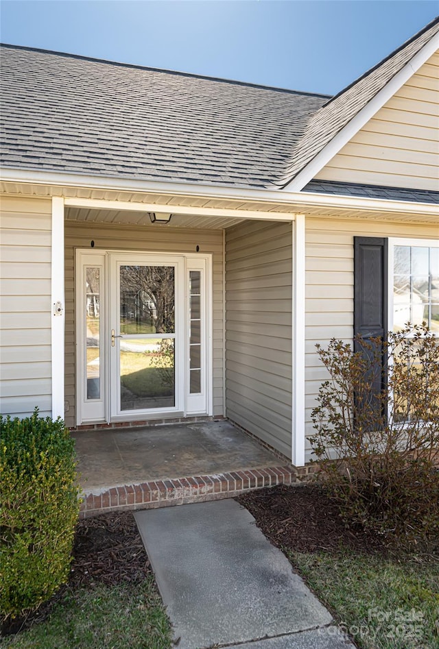 entrance to property featuring a shingled roof