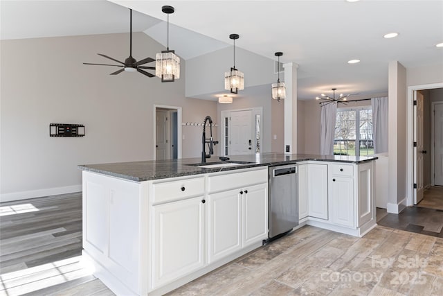 kitchen with a sink, lofted ceiling, light wood-style flooring, white cabinetry, and stainless steel dishwasher