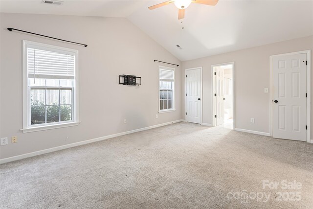 unfurnished bedroom featuring visible vents, baseboards, lofted ceiling, ensuite bathroom, and light colored carpet