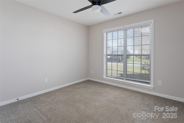 empty room featuring visible vents, carpet flooring, a ceiling fan, and baseboards