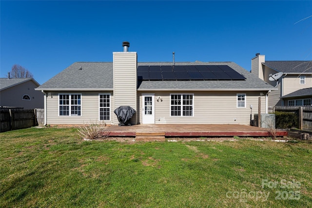 back of property with a yard, a fenced backyard, and a wooden deck