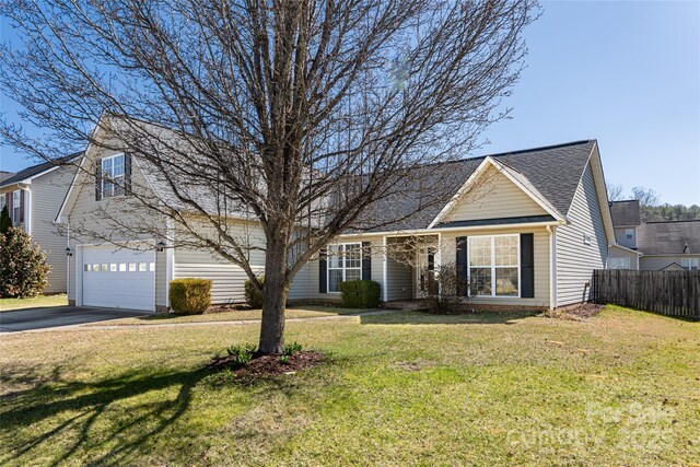 view of front facade featuring a front yard, fence, a garage, and driveway