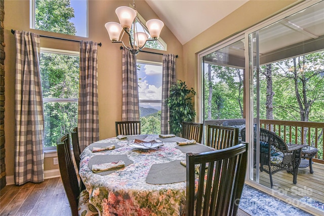 dining area with dark hardwood / wood-style flooring, a chandelier, and vaulted ceiling