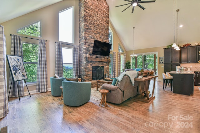 living room featuring light wood-type flooring, high vaulted ceiling, and a wealth of natural light