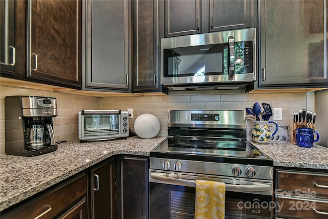 kitchen featuring dark brown cabinets, decorative backsplash, and appliances with stainless steel finishes