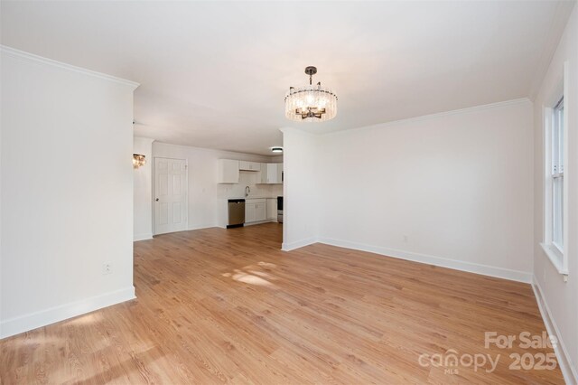 unfurnished living room with crown molding, light hardwood / wood-style flooring, and a chandelier