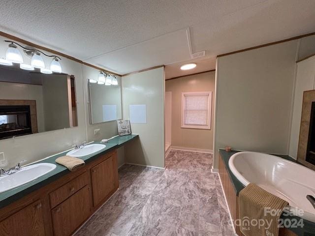 bathroom with a bathing tub, vanity, and a textured ceiling