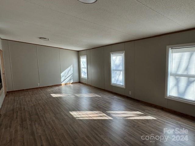 empty room with hardwood / wood-style floors and a textured ceiling