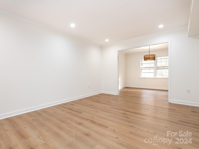 unfurnished room featuring light hardwood / wood-style floors and ornamental molding