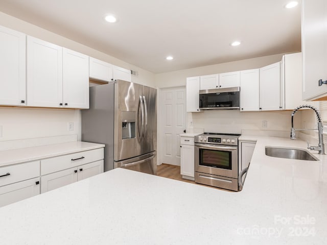 kitchen with white cabinetry, sink, and stainless steel appliances