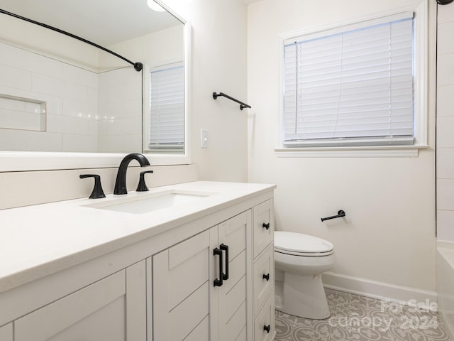 full bathroom featuring tile patterned floors, tiled shower / bath, vanity, and toilet