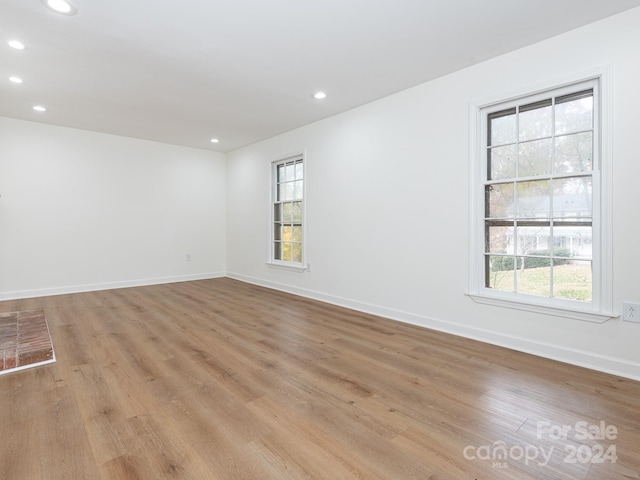 empty room with light hardwood / wood-style flooring and a healthy amount of sunlight