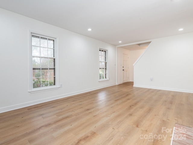 spare room with light wood-type flooring and a wealth of natural light