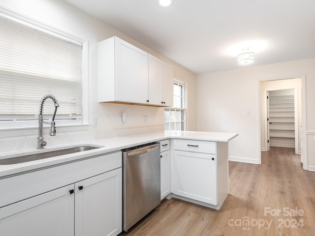 kitchen with dishwasher, sink, kitchen peninsula, light wood-type flooring, and white cabinetry