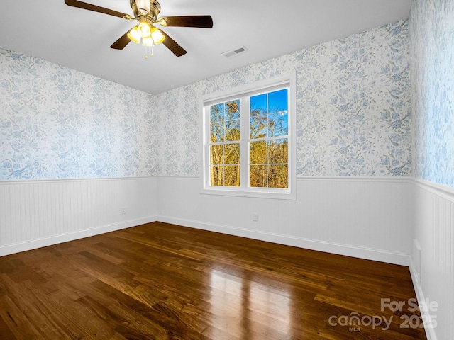 empty room featuring dark wood-type flooring and ceiling fan