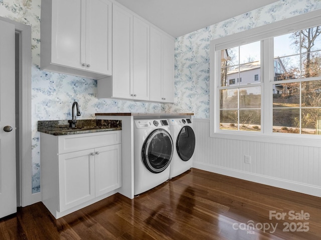 laundry area featuring sink, dark hardwood / wood-style floors, washer and clothes dryer, and cabinets