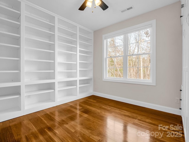 empty room with hardwood / wood-style floors and ceiling fan