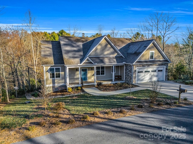 view of front of property with a garage, a front lawn, and covered porch