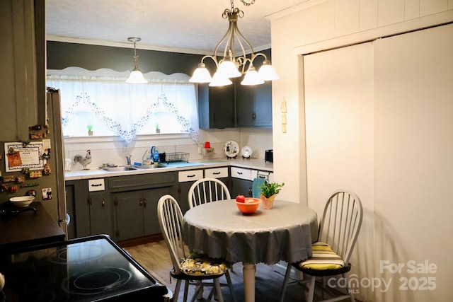 kitchen with crown molding, decorative light fixtures, sink, a notable chandelier, and range