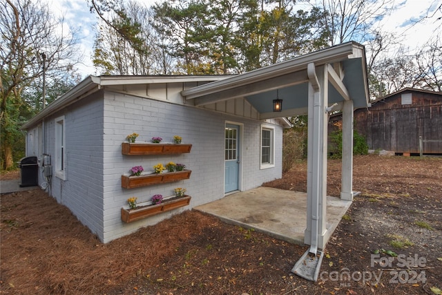 back of property featuring a storage shed and a patio