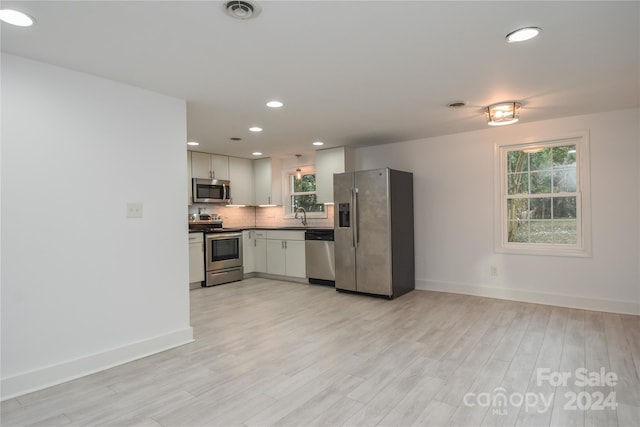 kitchen featuring sink, light hardwood / wood-style flooring, white cabinets, and appliances with stainless steel finishes