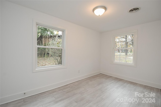 unfurnished room with light wood-type flooring and plenty of natural light