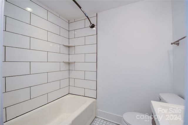 bathroom featuring tile patterned flooring, toilet, and tiled shower / bath