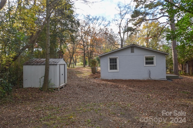 view of side of property with a storage shed