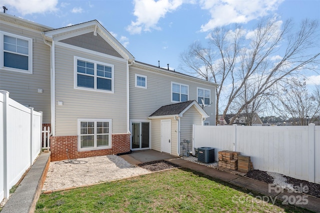 rear view of house with cooling unit, a patio area, and a yard