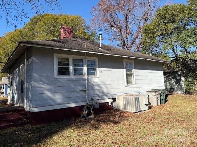 view of home's exterior featuring central air condition unit and a yard