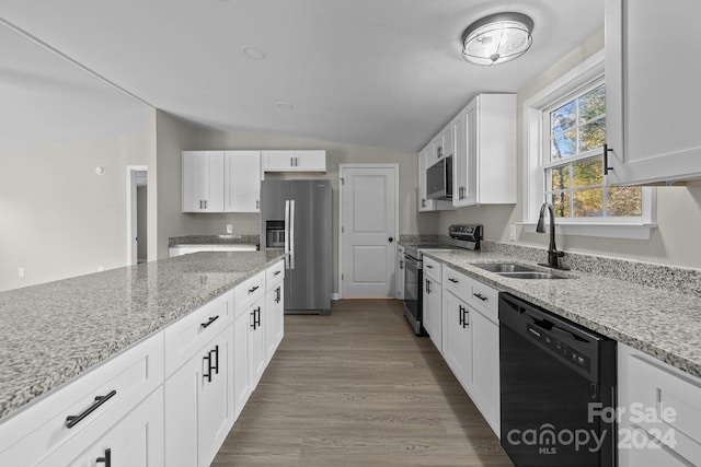 kitchen featuring sink, white cabinetry, stainless steel appliances, and vaulted ceiling