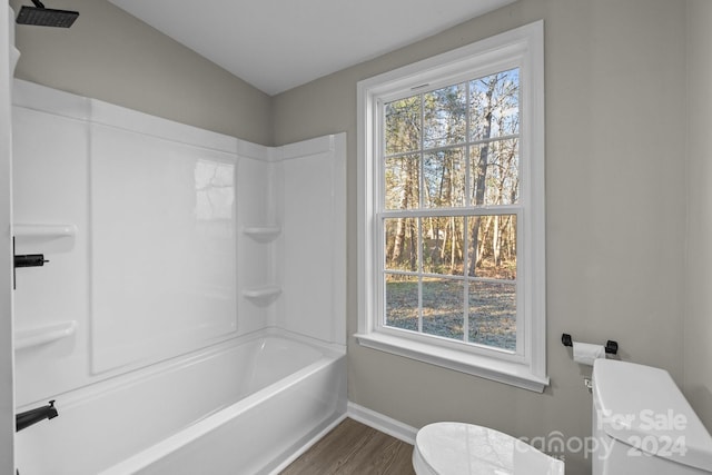 bathroom with shower / bathtub combination, toilet, wood-type flooring, and vaulted ceiling