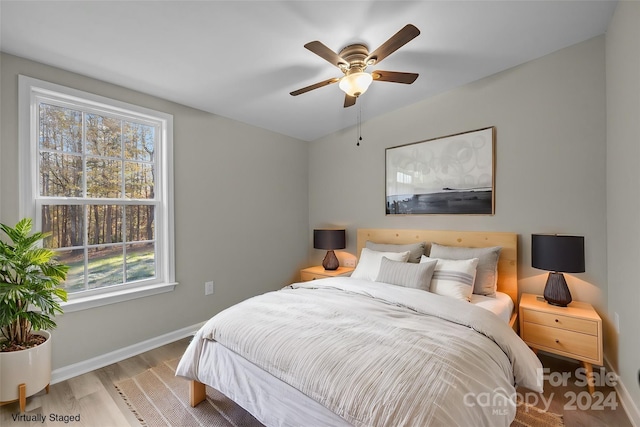 bedroom featuring light hardwood / wood-style flooring, multiple windows, and ceiling fan