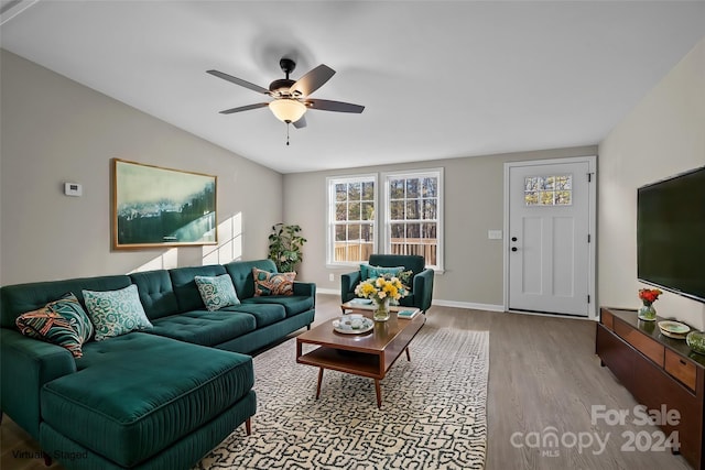 living room with ceiling fan, light hardwood / wood-style flooring, and vaulted ceiling