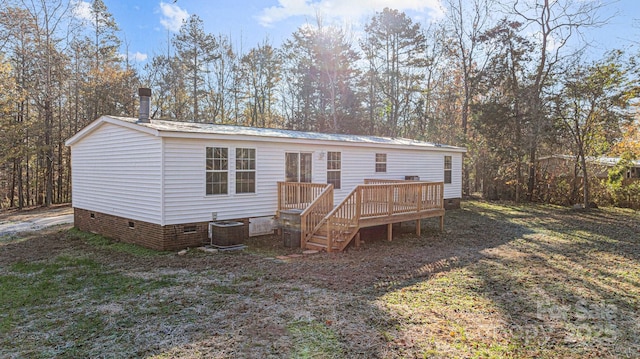 exterior space with central AC unit, a yard, and a deck