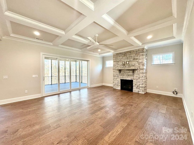 unfurnished living room with hardwood / wood-style floors, ceiling fan, a stone fireplace, and coffered ceiling