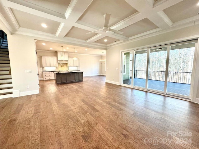 unfurnished living room with ceiling fan, wood-type flooring, and crown molding