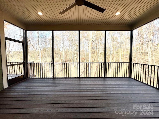 unfurnished sunroom with ceiling fan, plenty of natural light, and wood ceiling