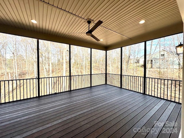 unfurnished sunroom with ceiling fan, a healthy amount of sunlight, and wooden ceiling