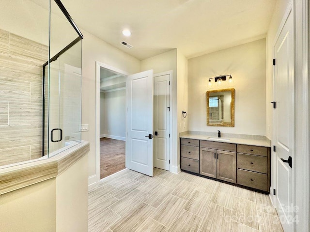 bathroom with vanity and a shower with shower door